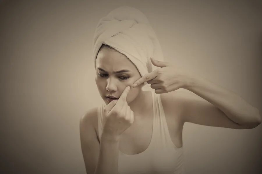 Mujer con toalla en el cabello cuidando su piel facial