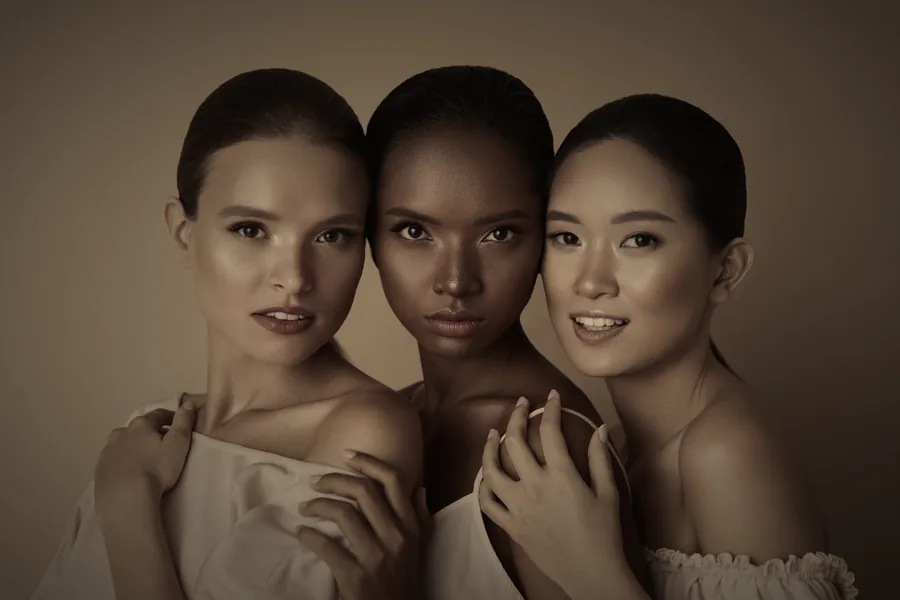 Tres mujeres de distintas etnias abrazadas, belleza diversa